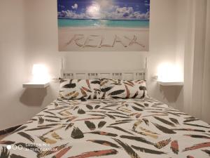 a bed in a bedroom with two lamps and a painting at CALAFELL 5 BEACH in Calafell
