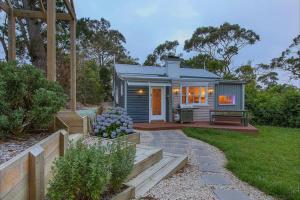 a tiny house in a garden with a patio at Blackheath Nook in Blackheath