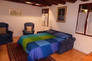 una camera con un letto colorato e due sedie di CHARMING HOUSE IN VENICE a Venezia