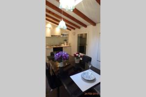 a dining room and kitchen with a table and flowers at CHARMING HOUSE IN VENICE in Venice