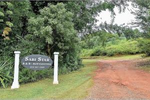 ein Schild an der Seite einer unbefestigten Straße in der Unterkunft Sabie Star in Sabie