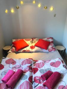 un letto con cuscini rossi e rosa di Stajnia pod Dębem a Starachowice