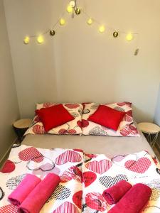 łóżko z czerwono-białymi kocami i poduszkami w obiekcie Stajnia pod Dębem w mieście Starachowice