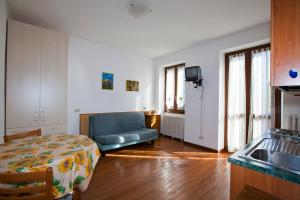 a living room with a blue couch and a kitchen at Villa Presolana in Castione della Presolana