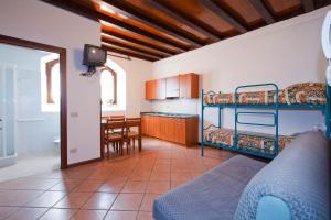 カスティオーネ・デッラ・プレゾラーナにあるVilla Presolanaのリビングルーム(二段ベッド2台付)、キッチンが備わります。