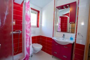 a red bathroom with a toilet and a sink at Apartments Loncar in Tučepi +89 photos