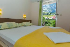 a bedroom with a bed with a view of a mountain at Apartments Loncar in Tučepi