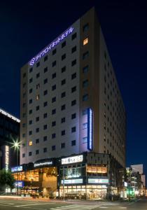 un edificio de hotel con un cartel de neón encima en Daiwa Roynet Hotel Sendai, en Sendai