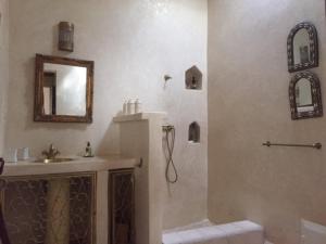 a bathroom with a shower and a sink and a mirror at Villa Salvatore in Ghazoua