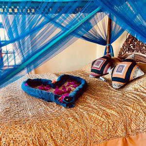 a bed with a blue canopy with flowers on it at Zanzibar Palace Hotel in Zanzibar City