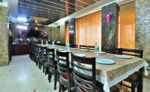 uma longa sala de jantar com uma longa mesa e cadeiras em THE BONLON INN-NEAR BLK HOSPITAL em Nova Deli