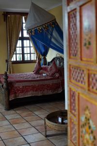 a bedroom with a bed with a blue canopy at Zanzibar Palace Hotel in Zanzibar City