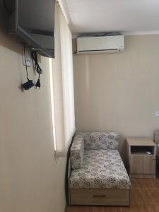 Kleines Zimmer mit Sofa und TV in der Unterkunft У Сергея и Веры in Gagra