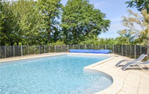 a swimming pool with two chairs next to a fence at Beautiful Home In Durfort Lacapelette in Durfort