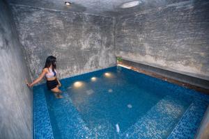 a woman standing next to a swimming pool at Sati Villa Kandy Sri Lanka in Kandy