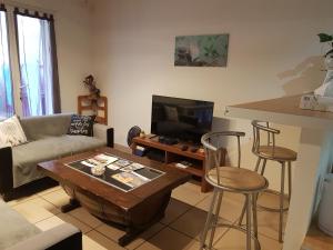 uma sala de estar com um sofá e uma mesa em Appart B tout confort, climatisé sur Coursan em Coursan