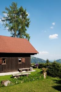 uma cabana de madeira com um banco à frente em Jagdhütte Gammeringalm em Spital am Pyhrn