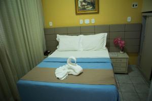 a hotel room with a bed with a swan on it at Hotel Litoral Sul in Coruripe