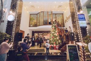 Un grupo de personas en un centro comercial con un árbol de Navidad en Hai Bay Hotel & Restaurant en Hanói
