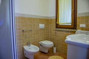 a bathroom with a toilet and a sink at Villa Denise in Campiglia Marittima