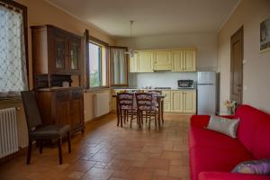 a living room with a red couch and a kitchen at Villa Denise in Campiglia Marittima