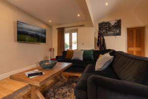 ein Wohnzimmer mit einem Sofa und einem Couchtisch in der Unterkunft Lodge House - Windermere - Private Garden in Windermere