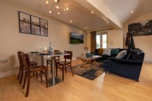 a living room with a table and a couch at Lodge House - Windermere - Private Garden in Windermere