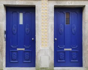 two blue doors on the side of a building at Vitoria's Terrace Apartments in Porto