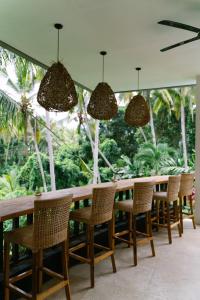 a long table and chairs with trees in the background at Villa Dua Hati in Ubud