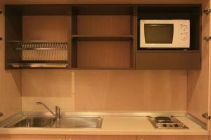 a kitchen with a sink and a microwave at Silver Residence Hotel in Bagnolo in Piano