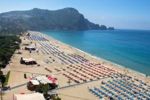 a beach with a lot of umbrellas and the ocean at Alaiye Kleopatra Hotel in Alanya