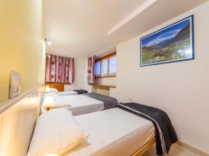 een hotelkamer met drie bedden en een foto aan de muur bij Cervinia Apartment in Breuil-Cervinia