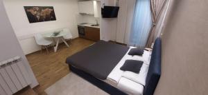 a bedroom with a bed and a table and a kitchen at M48 apartments in Belgrade