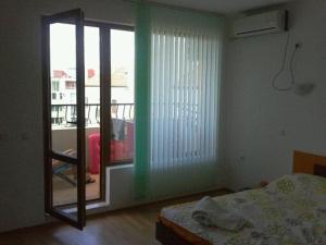 a bedroom with a bed and a sliding glass door at Apartment Comfort in Sunny Beach