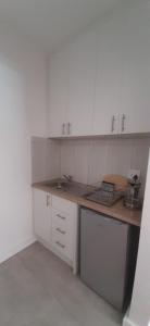 a kitchen with white cabinets and a wooden counter top at The Observatory, Luxury Suite in Observatory Home in Johannesburg