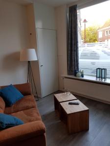 een woonkamer met een bank, een tafel en een raam bij Studio 82 b in Middelburg