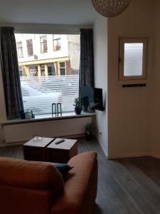 een woonkamer met een bank en een groot raam bij Studio 82 b in Middelburg