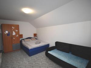 Habitación pequeña con 2 camas y sofá en Apartment Kolman, en Bohinj