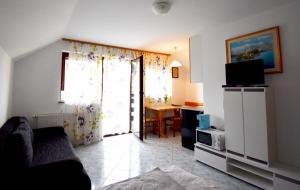 a living room with a couch and a tv at Apartment Kolman in Bohinj