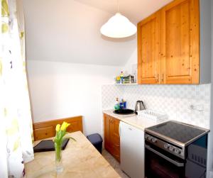 małą kuchnię z drewnianymi szafkami i kuchenką w obiekcie Apartment Kolman w Bohinju