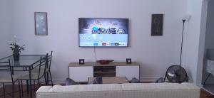 a living room with a couch and a tv on the wall at The Observatory, Luxury Suite in Observatory Home in Johannesburg