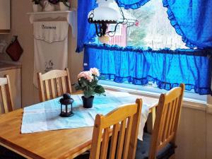 6 person holiday home in Vevelstad في Vevelstad: طاولة غرفة الطعام مع إناء من الزهور عليها