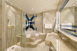 un bagno con vasca, lavandino e doccia di Glärnischhof by TRINITY a Zurigo