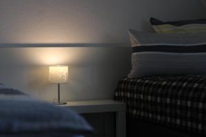 a lamp sitting on a table next to a bed at Rentaroom-Kassel in Kassel