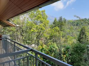 uma varanda de uma casa com vista para a floresta em Munnar Minds Homestay em Munnar
