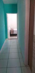 a room with green walls and a white floor and a doorway at Arraial Sobradinho in Arraial do Cabo