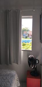 1 dormitorio con ventana y ventilador junto a la cama en Arraial Sobradinho, en Arraial do Cabo