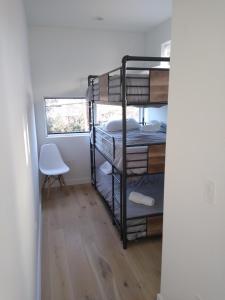a room with three bunk beds and a chair at Stunning Modern Home w Pool & Hot Tub in DT Austin in Austin
