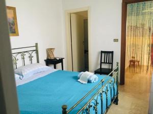 una camera da letto con un grande letto con lenzuola blu di B&b Mammannina a Carovigno