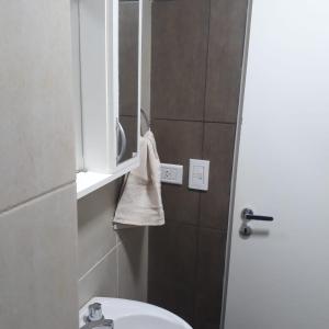 a bathroom with a sink and a mirror and a toilet at Depto Temporario La Plata in La Plata
